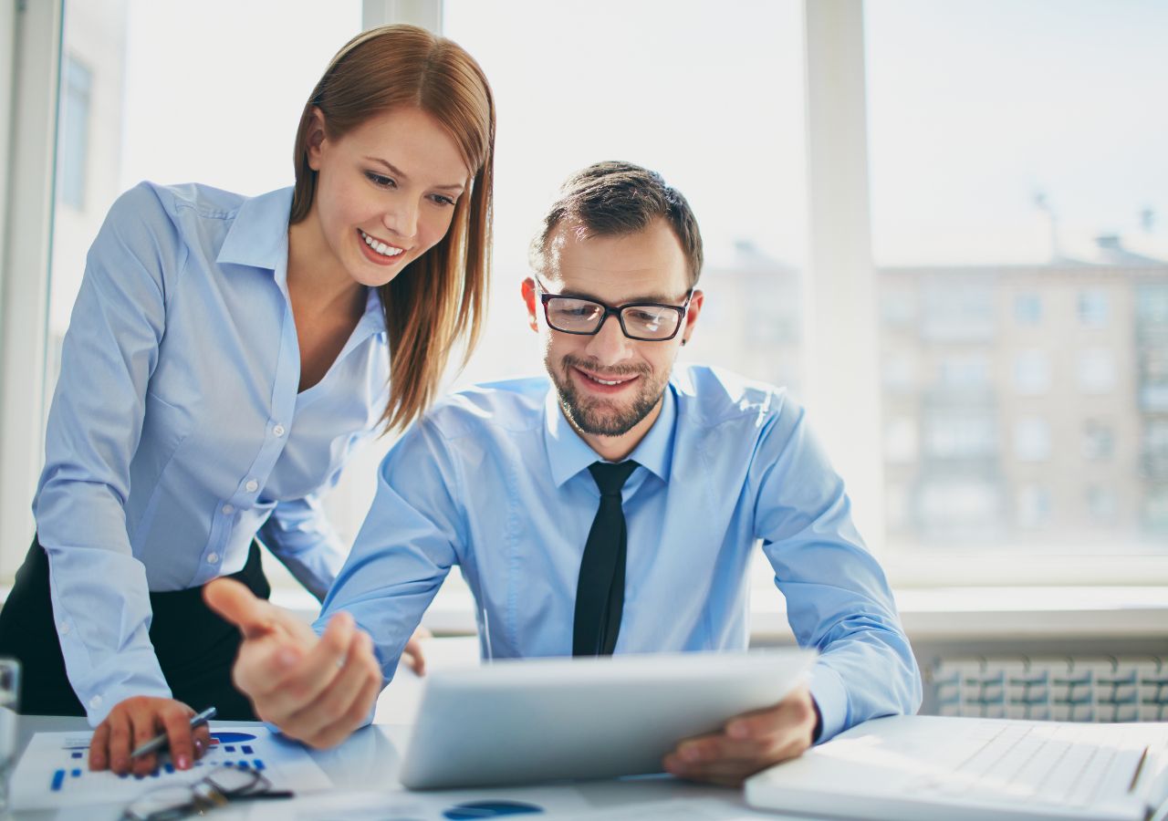 Photo of man and woman looking over document to illustrate ways to motivate your employees