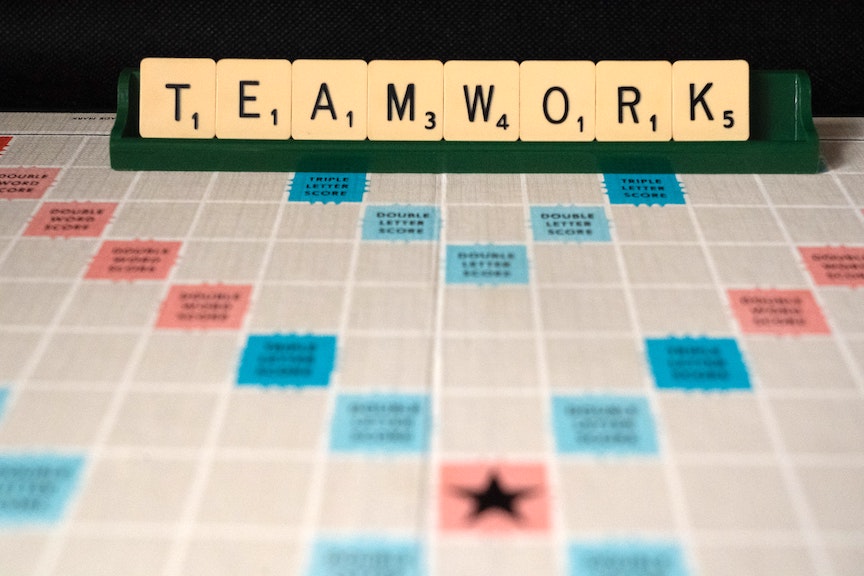 Photo of Scrabble Board that reads out "Teamwork."