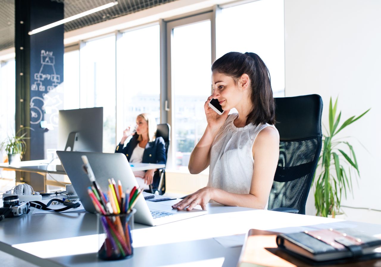 Photo of woman on phone in office to illustrate: Is professionalism becoming underrated?