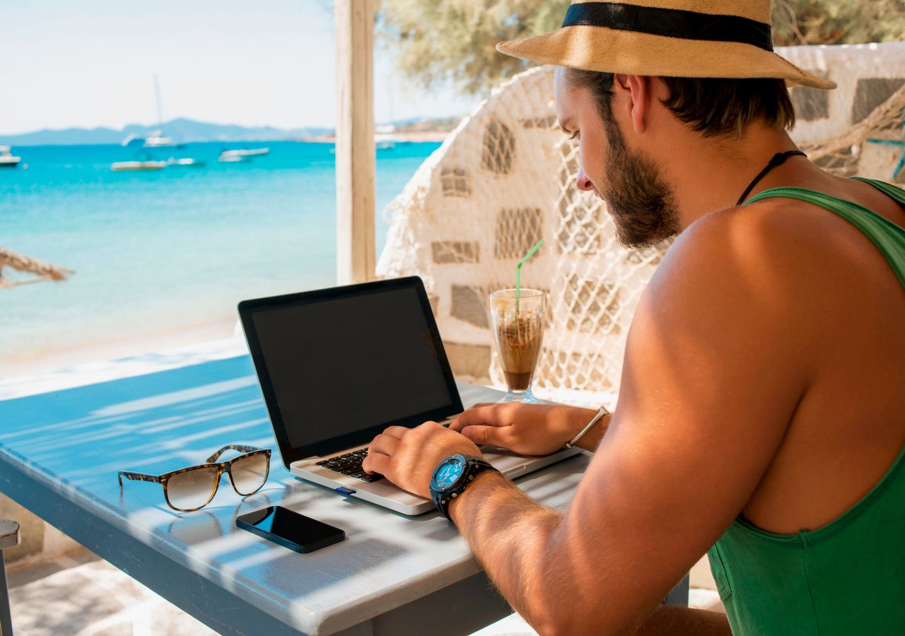 Cost of a bad hire photo of man on a computer in the Caribbean to illustrate the cost of a bad hire