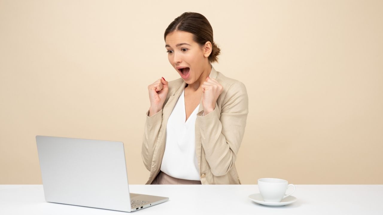 Excited woman looking at computer about promoting from within a company.