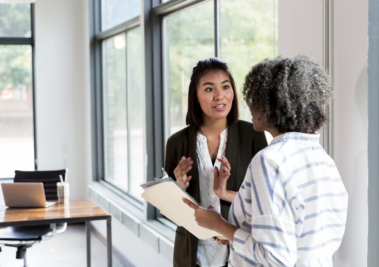 photo of two women talking to illustrate what to consider when switching jobs