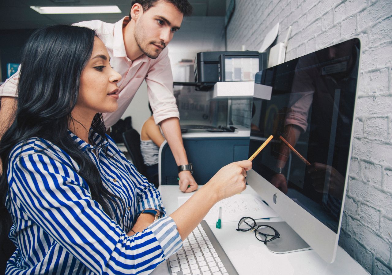 Photo of woman pointing to computer to illustrate 5 signs a Company is the Right Fit.