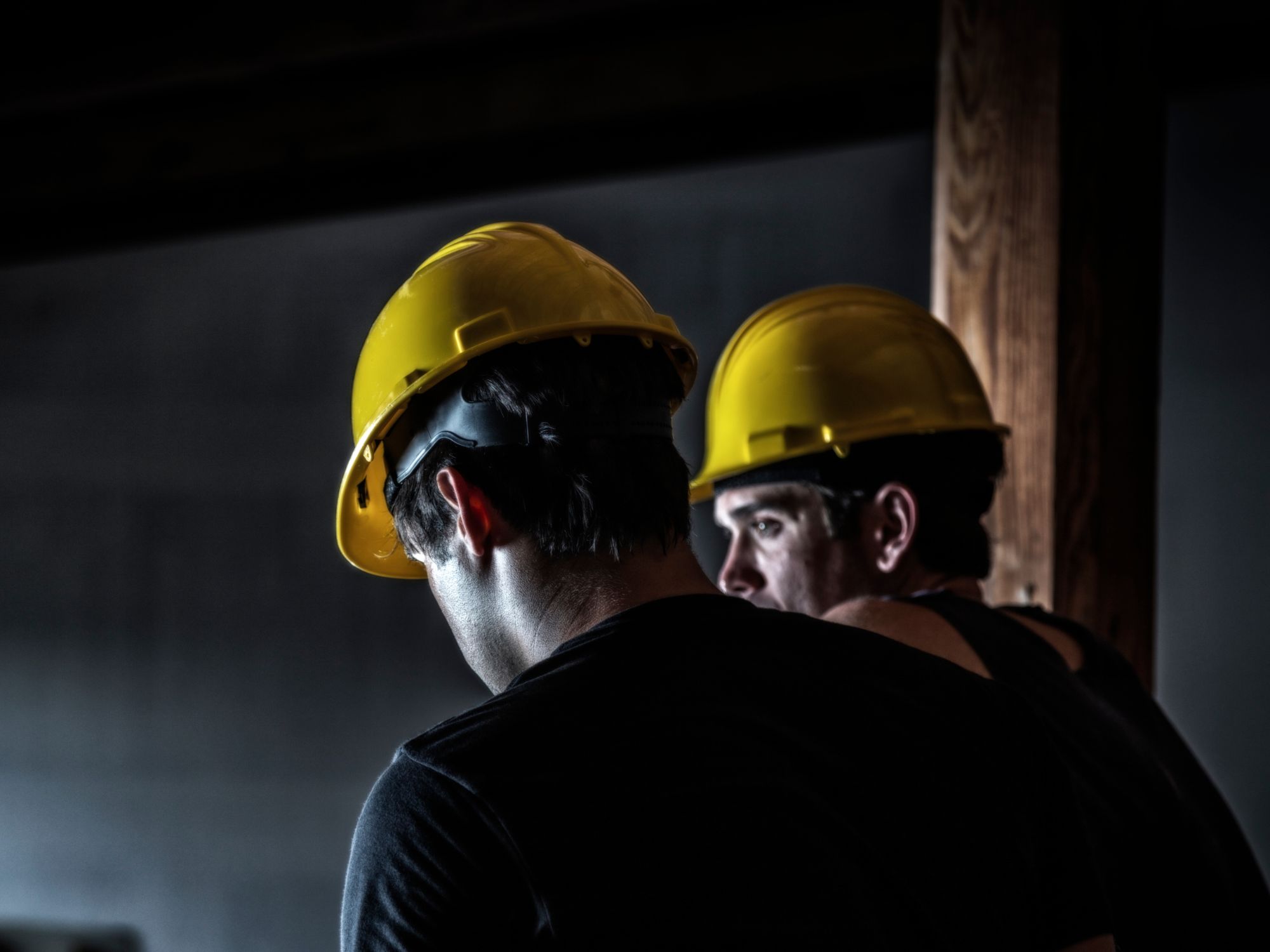 Photo of two men in yellow hard hats to illustrate night shift safety tips.