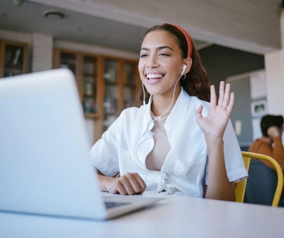 Photo of woman smiling at computer to illustrate how to stay positive during a job search.