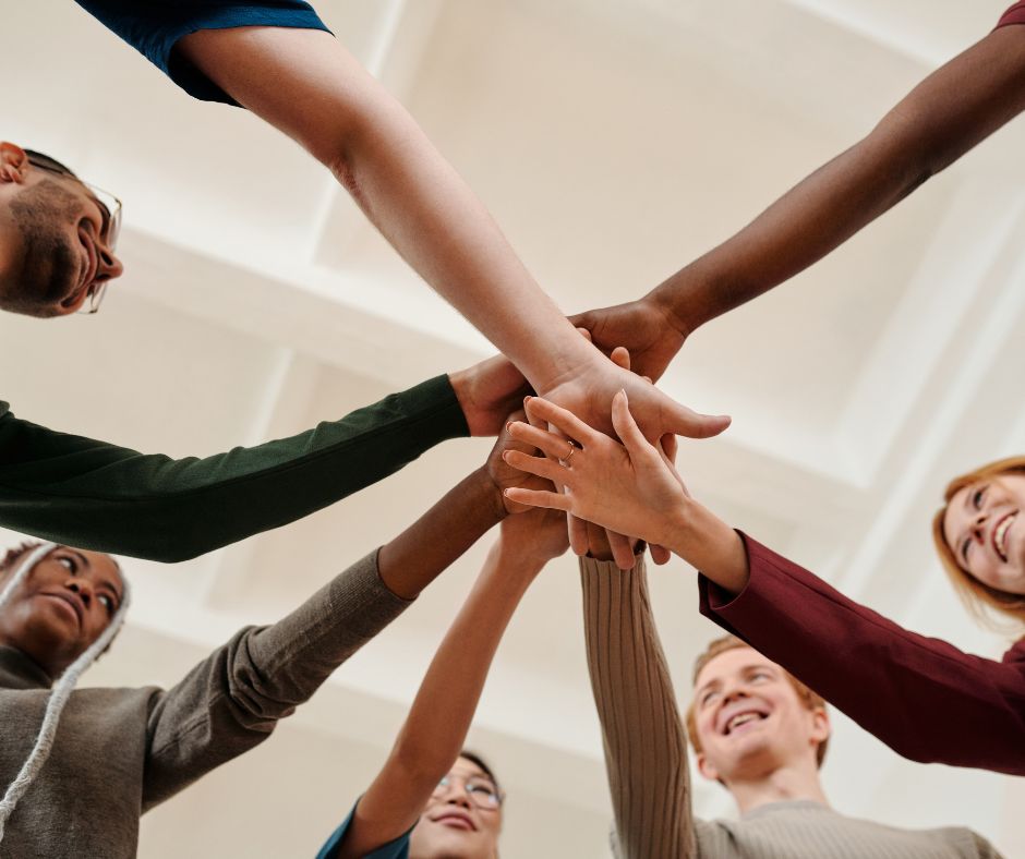 Photo of workers grabbing hands to illustrate how to increase employee retention.