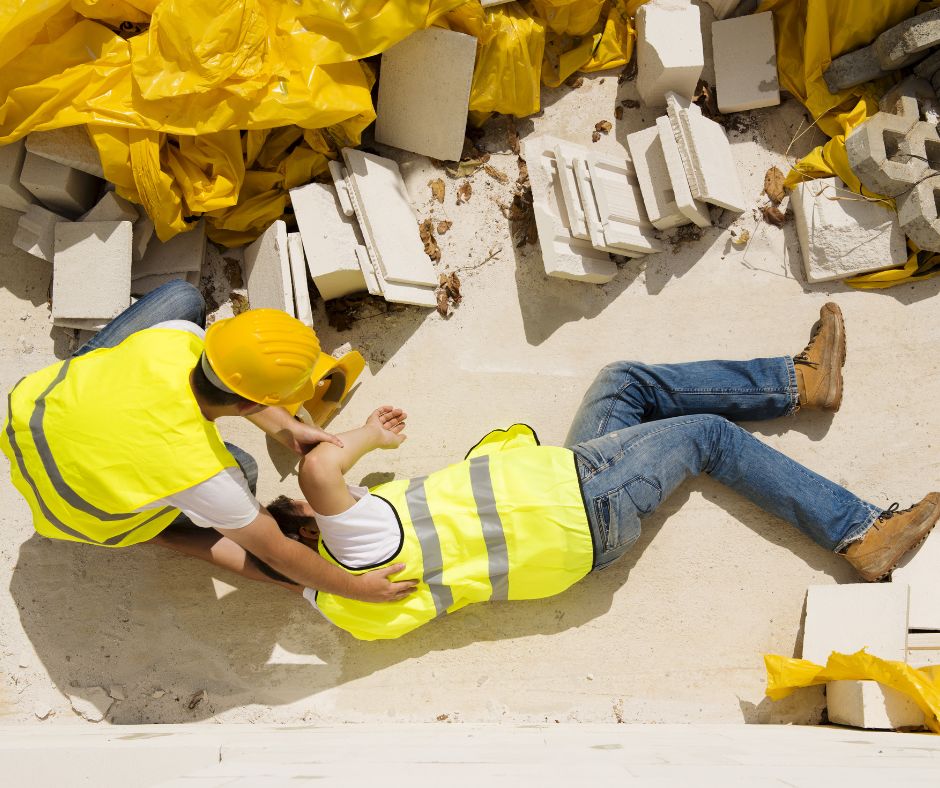 Photo of warehouse worker on the ground being helped by another worker to illustrate the risks of not following procedure.