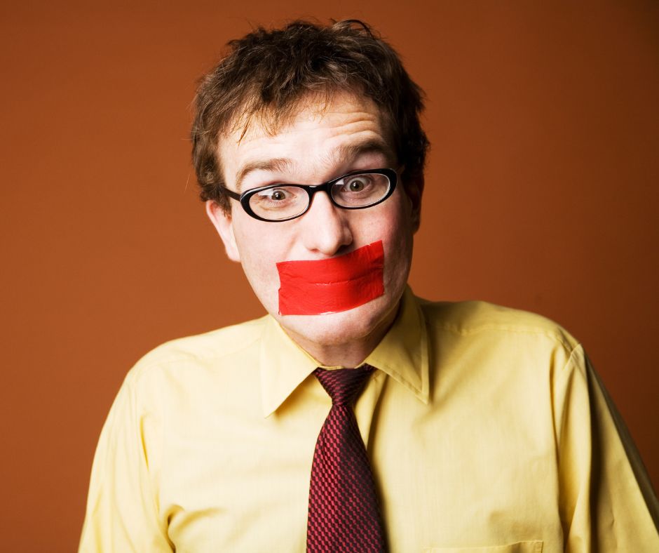 Photo of man in yellow shirt with red tape over his mouth to illustrate what to do when employees don't speak up.