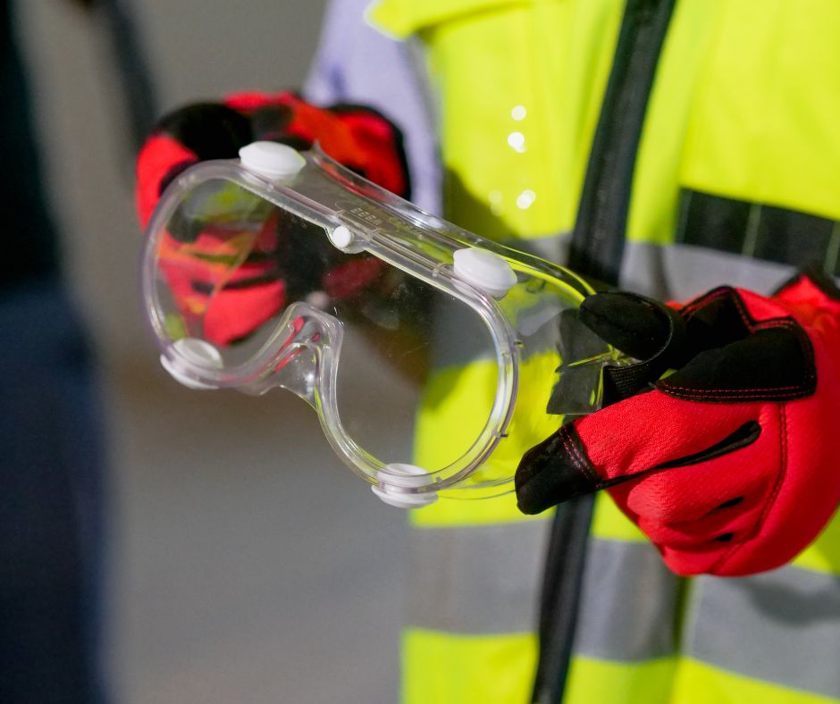 Photo of man holding safety goggle to illustrate importance of a workplace safety culture.