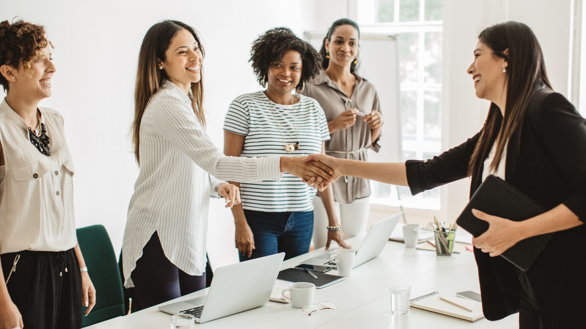 Photo of five women in office to illustrate onboarding tips.