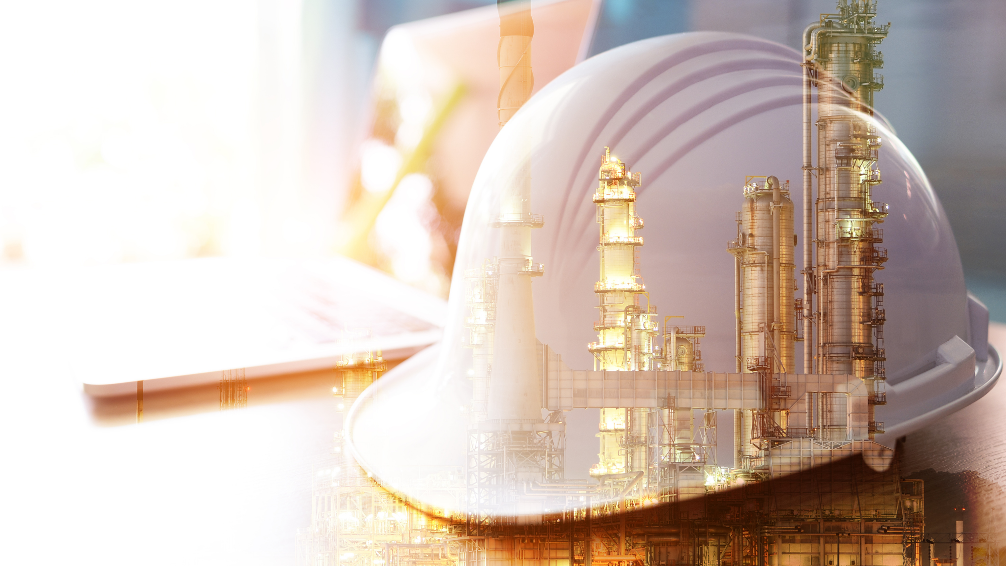 A close-up image of a white safety hard hat with a refinery or industrial processing plant reflected across its surface through a double-exposure effect.