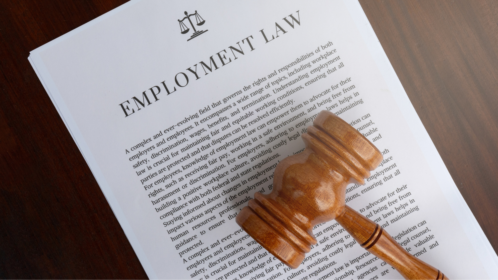 Wooden judge’s gavel resting on a document titled “Employment Law.”